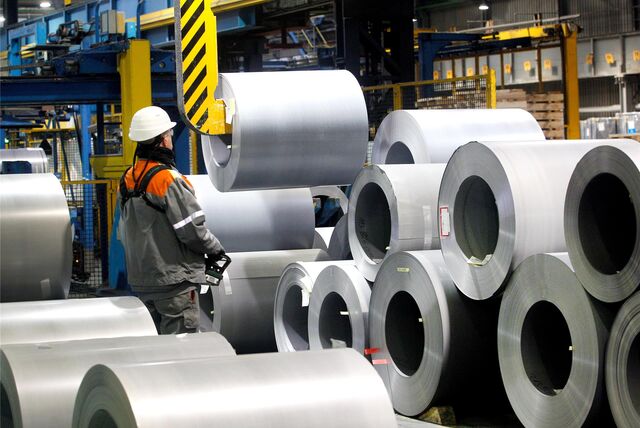 Coils mit CO2-reduziertem Spezialstahl werden bei Thyssenkrupp von einem Mitarbeiter weitertransportiert.