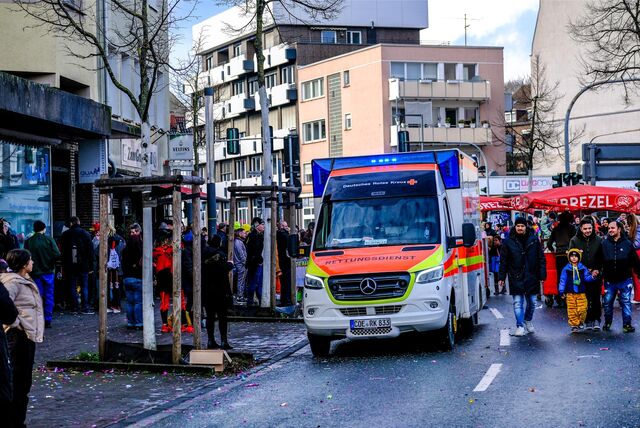 Ein Rettungswagen fährt durch eine Menschenmenge beim Rosenmontagszug in Recklinghausen.