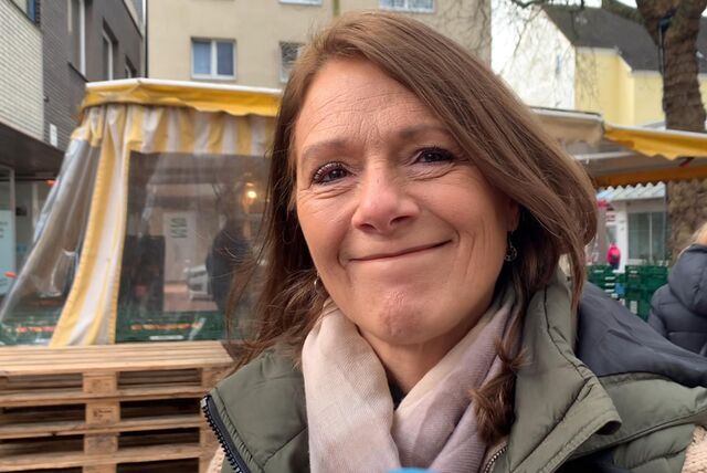 Eine Kundin steht in der Altstadt in Castrop-Rauxel. Im Hintergrund sind Marktstände zu sehen.