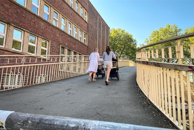 Zwei Frauen mit Kinderwagen gehen über die Brücke an der Lindemannstraße.