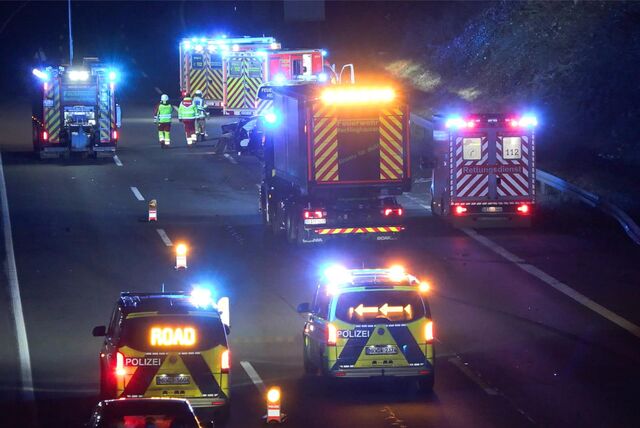 Auf der A2 stehen in der Nacht zwei Polizeiautos, drei Rettungswagen und zwei Feuerwehrfahrzeuge. Feuerwehrleute laufen zwischen den Fahrzeugen her.