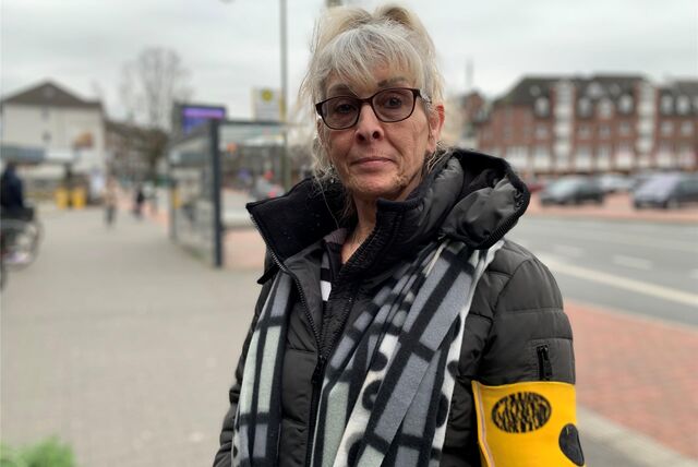 Gabriele F. steht in Waltrop in der Nähe von Edeka. Im Hintergrund zu sehen sind eine Bushaltestelle, die Straße Am Moselbach und der große Parkplatz der Waltroper Stadtmitte.