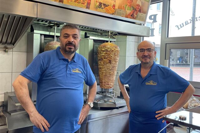 Durdu und Ali Sarialtun, Mitarbeiter im City-Kebap-Haus in Haltern, stehen vor einem Dönerspieß.