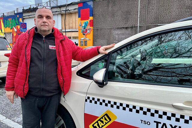 Taxifahrer Ali Koç steht in Dortmund neben seinem Taxi.