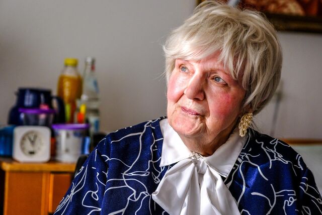 Ein Porträt von Gerda Döring, die vor einem Bett sitzt.