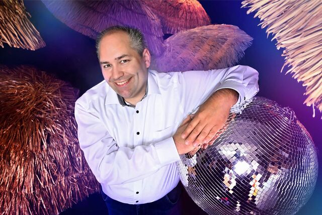 Ein Mann lehnte mit dem Arm auf einer Disco-Kugel.