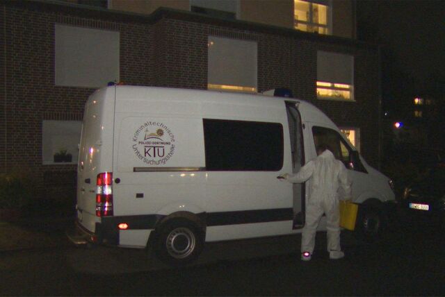 Ein Mann mit Schutzanzug an einem weißen Lieferwagen der Kriminaltechnik der Polizei Dortmund