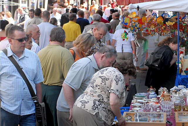 Menschen schauen sich bei einem Trödelmarkt in Castrop-Rauxel an den Ständen der Händler um.