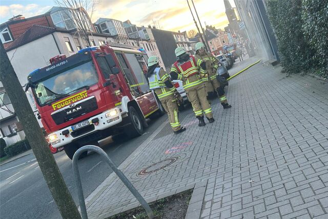 Ein Feuerwehrwagen und Einsatzkräfte stehen vor einem Haus, aus dem Rauch dringt in Recklinghausen.