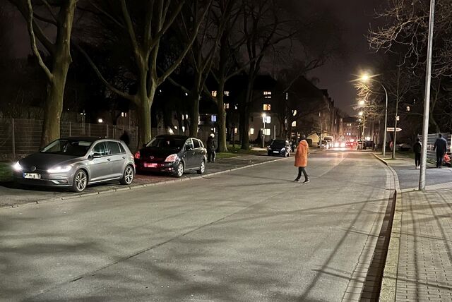 Eine Straßenprostituierte überquert die Bergmannstraße in der Dortmunder Nordstadt und geht auf ein parkendes Auto zu.