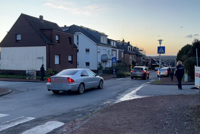 Autos fahren vor einer Schule vor.