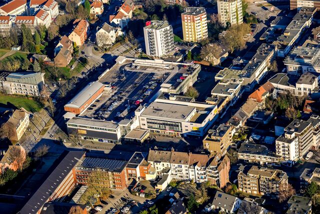 Städtische Bürogebäude und Hochhäuser. Im Zentrum zu sehen auch das obere Parkdeck mit Autos darauf.