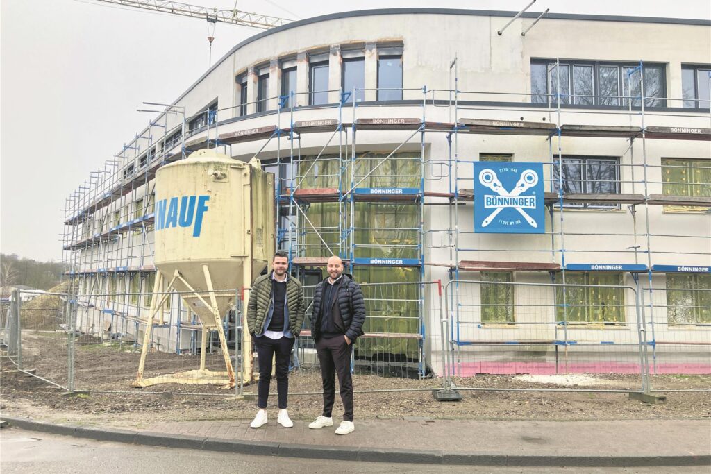 Zwei Männer vor einem Neubau.