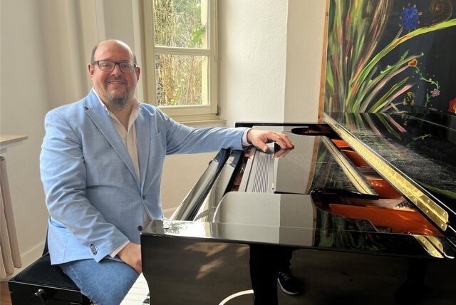 Ein Mann sitzt an einem Piano.