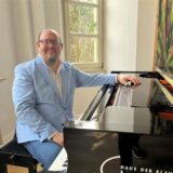 Ein Mann sitzt an einem Piano.