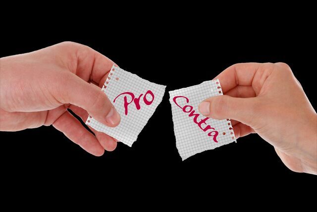 Zwei Hände sind vor einem schwarzen HIntergrund abgebildet. Jede Hand hält einen Zettel in der Hand. Auf dem einen Zettel steht „pro“ und auf dem anderen „contra“.