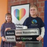 Zwei Mädchen halten ein Schild