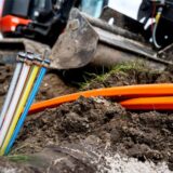 Verschiedene Glasfaserkabel in der Hand eines Arbeiters.