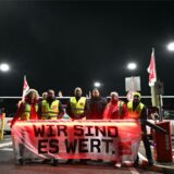 ÖPNV-Streikende in NRW stehen hinter einem Plakat mit der Aufschrift „Wir sind es wert.“