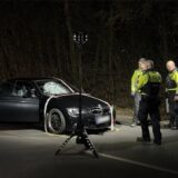 Polizisten stehen in der Dunkelheit vor einem beschädigten Unfallwagen in Recklinghausen.