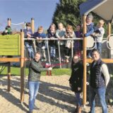 Bürgermeister Marcel Mittelbach gibt ein Spielgerät frei, auf dem viele Kinder stehen.