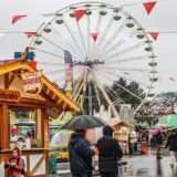 Besucher gehen bei der Osterkirmes „Fredolino“ in Dortmund über den Kirmesplatz am Fredenbaum.