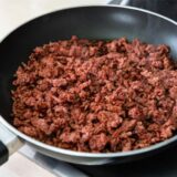 Veganes Hack wird in einer Pfanne angebraten.