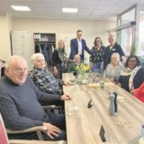 Ein Gruppenfoto aus der neuen Tagespflege in Waltrop: Am Tisch sitzen sechs Senioren, die Bingo spielen, dahinter stehen Geschäftsführer Christian Lange, Pflegedienstleiterin Anne Krümpel und zwei Mitarbeiterinnen.