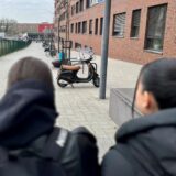 Die Berufsschülerinnen Almina, Liva und Irem stehen an der Benno-Elkan-Allee in Dortmund, sie sind unscharf von hinten zu sehen.