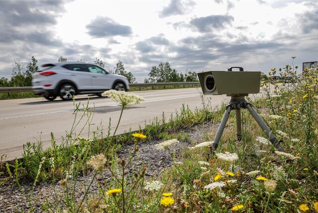 Ein mobiles Radargerät am Straßenrand und ein vorbeifahrendes Auto.