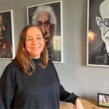 Sabine Hoffarth in ihrer Seelenwerkstatt. An den Wänden hängen Bilder, die als Karikaturen den Dalai Lama, Albert Einstein und Siegmund Freud zeigen.