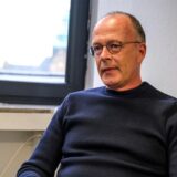 Ein Mann mit Brille und blauem Pulli.