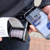 Ein Mitarbeiter vom Kommunalen Ordnungsdienst ist auf der Suche nach Falschparkern fündig geworden und druckt Knöllchen.