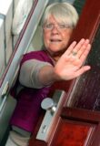 Eine Seniorin verwehrt jemandem den Zutritt zu ihrer Wohnung.