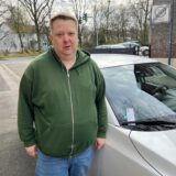 Ein Mann steht vor seinem silberfarbenen Auto an der Birkenstraße in Herten-Bertlich, an der Windschutzscheibe ist ein Knöllchen der Stadt Herten erkennbar.