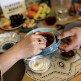 Eine Frau nimmt beim Fastenbrechen Iftar eine Dattel aus einer Schale, die ihr Mann ihr über dem Tisch reicht.