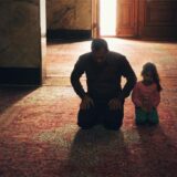 Ein Vater und seine Tochter knien während des Ramadan in einer Moschee und beten.