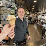 Eis-Verkäufer Hassan Jahaj reicht in der Gelateria San Remo in Recklinghausen ein Eis über die Theke.