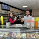 Zwei Kellner stehen im Eiscafé Adriano hinter der Theke und verkaufen Eis.