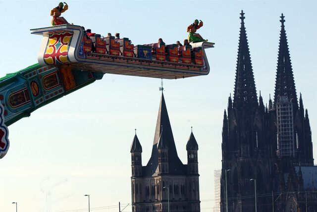 Das Fahrgeschäft „1001 Nacht“ dreht sich auf der Deutzer Kirmes in Köln, im Hintergrund sind Groß St. Martin und der Kölner Dom zu sehen.