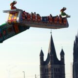 Das Fahrgeschäft „1001 Nacht“ dreht sich auf der Deutzer Kirmes in Köln, im Hintergrund sind Groß St. Martin und der Kölner Dom zu sehen.