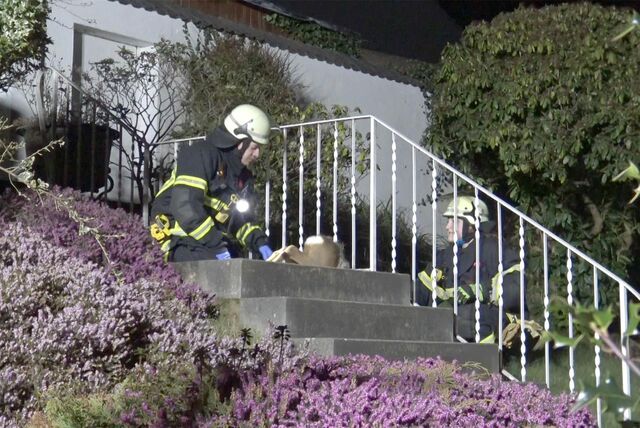 Zwei Feuerwehrmänner hocken neben dem Reh.