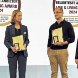 Fünf Menschen stehen bei einer Preisverleihung auf einer Bühne.