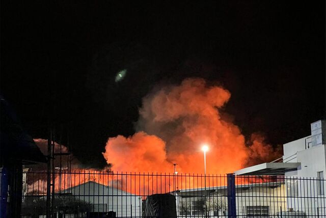 Feuerschein und Rauchsäule über einem Gewerbebau.