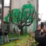 Das Banksy-Kunstwerk wurde mit weißer Farbe verunstaltet, nachdem es am Wochenende an der Seite eines Wohnhauses in der Hornsey Road in Finsbury Park auftauchte. Das grüne Werk des Banksy des Streetart-Künstlers war auf eine weiße Wand hinter einem kahlen Baum gesprüht worden und erweckt aus dem richtigen Blickwinkel den Anschein, der Baum trage Blätter. Darunter ist im Stil des bis heute anonymen Künstlers eine Frau zu sehen, die ein Sprühgerät in der Hand hält und das Werk betrachtet.