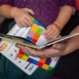 Eine Mutter liest ihrer kleinen Tochter im Kinderzimmer aus einem Buch vor.