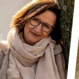 Eine Bildmontage zeigt ein Porträtbild und eines einer Frau in einem Strohlager.