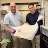 Nunzio Marcucci und Dustin Burbaum zeigen einen rund 20 Kilogramm schweren weißen Heilbutt.