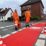 Rote Straßenmarkierung wird erneuert.