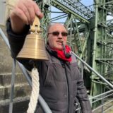 Karsten Rybiak steht mit Schiffsglocke in der Hand und Pfeife im Mund am LWL-Museum Schiffshebewerk Henrichenburg.